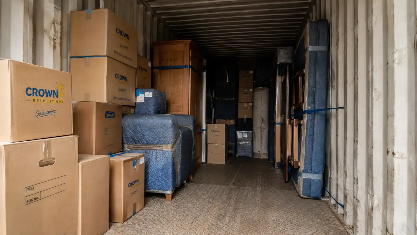 Removal container packed floor-to-ceiling with furniture and boxes from a 3-bedroom home