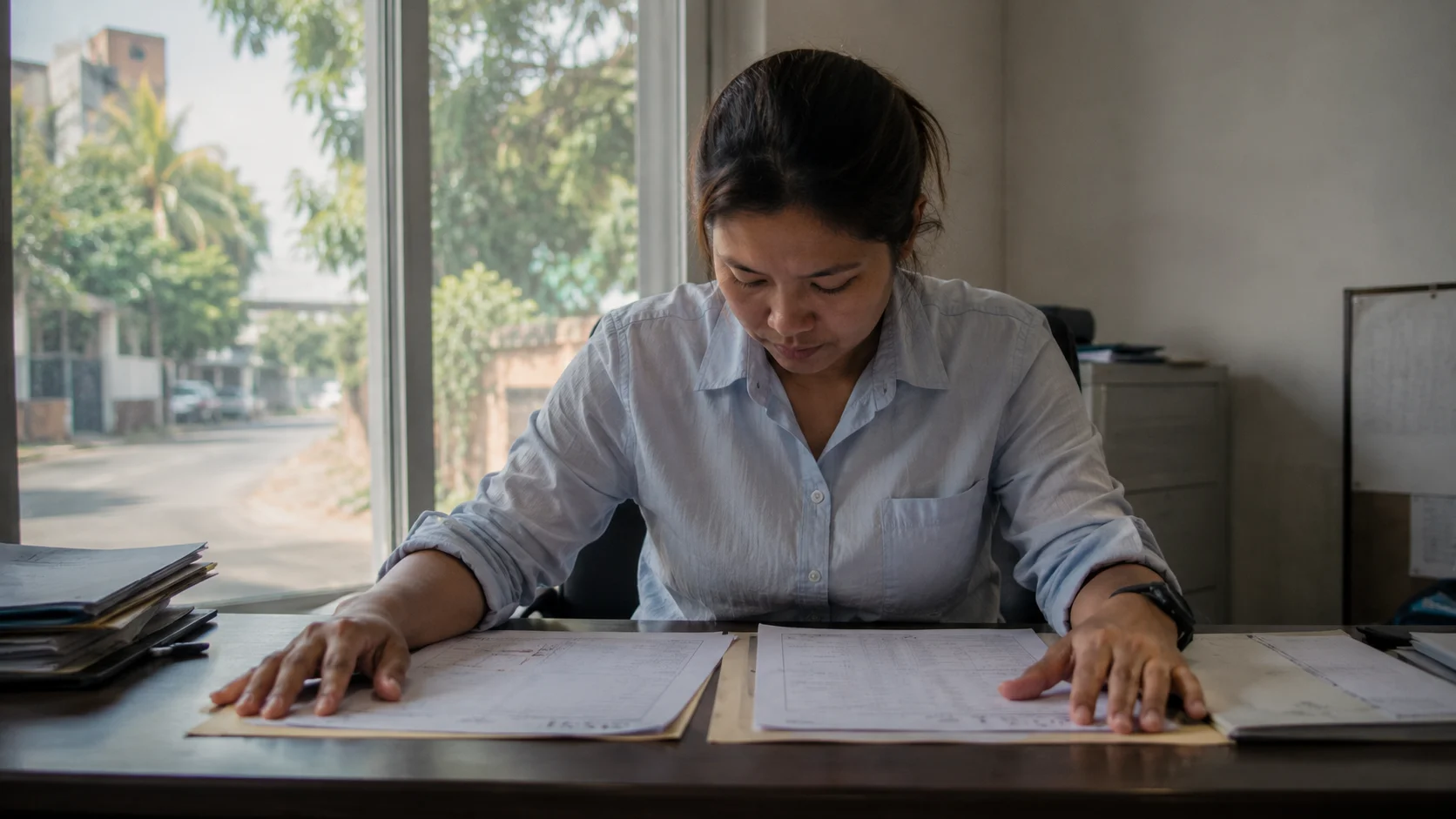 Staff member reviewing paperwork at the front office of a Thai logistics company