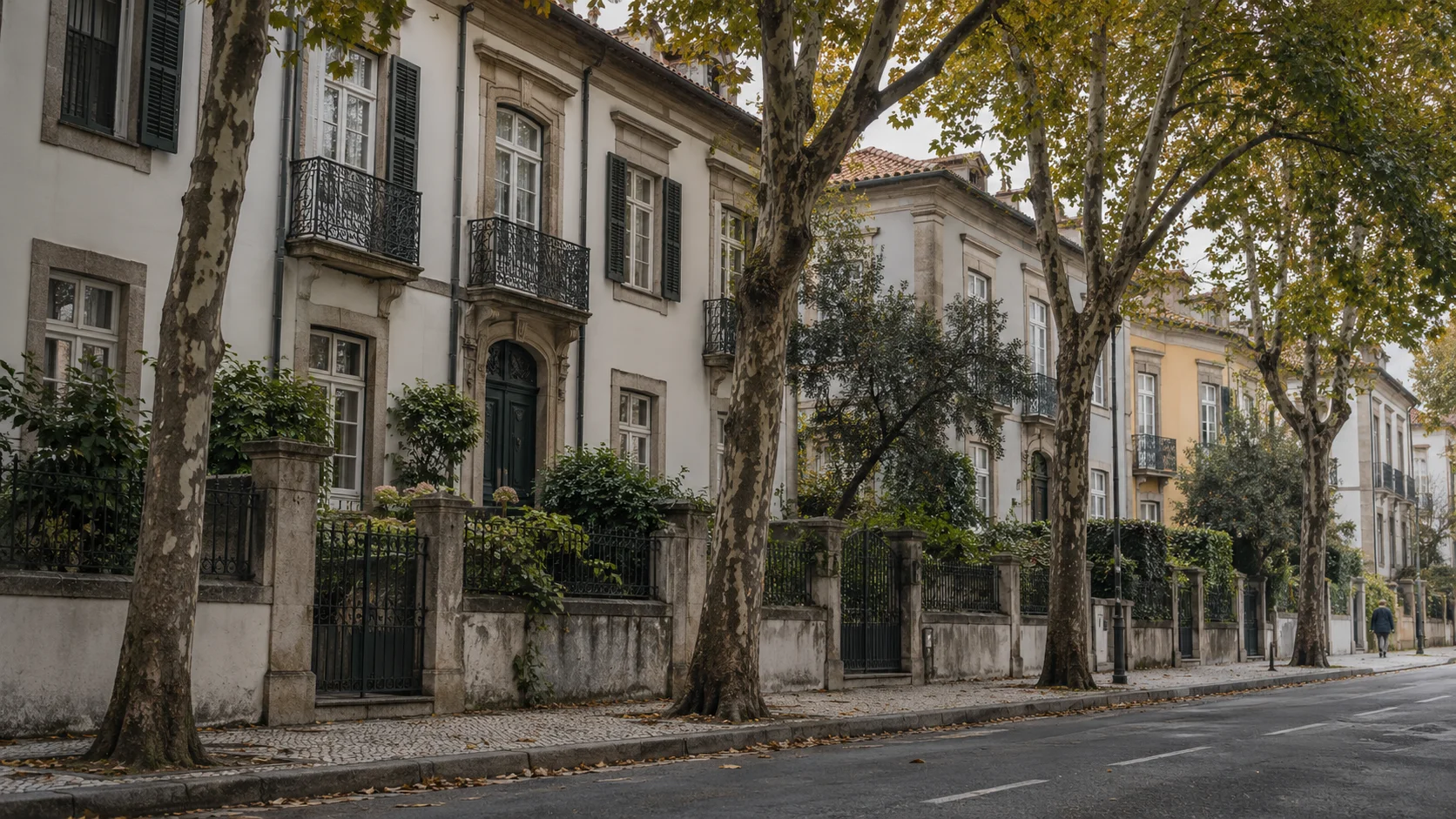 Tree-lined street of large townhouses behind iron gates and garden walls, illustrating the high-value homes the AIMI targets